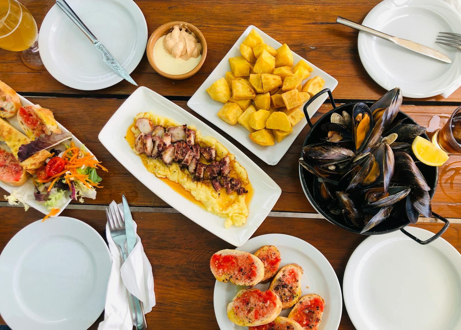 An appetizing display of Mediterranean seafood dishes at a restaurant table, featuring clams and regional delicacies.